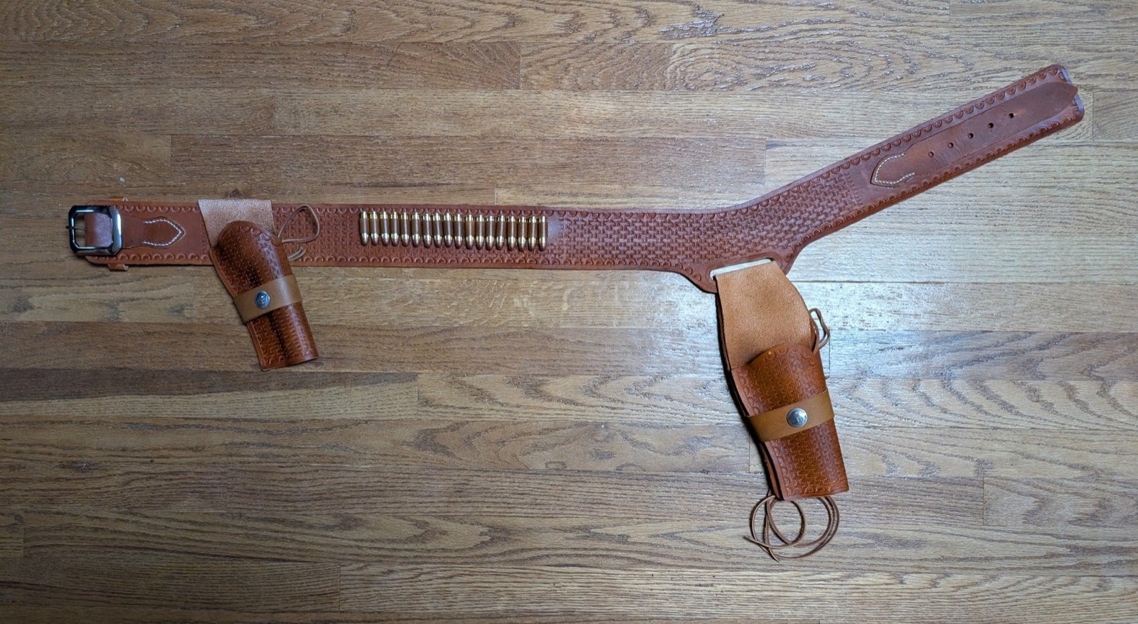 Tooled leather sheath being fitted to a knife with a wood and brass handle